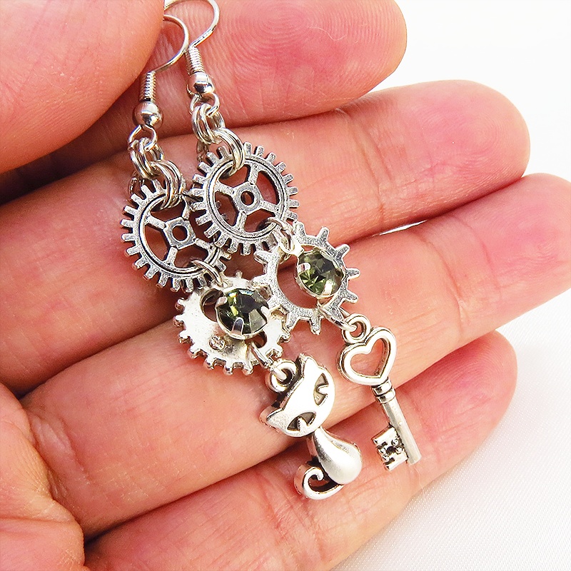 アンティークシルバー 猫と歯車・カギを組み合わせたスチームパンク風ピアス クリアガラス 深緑 サージカル可