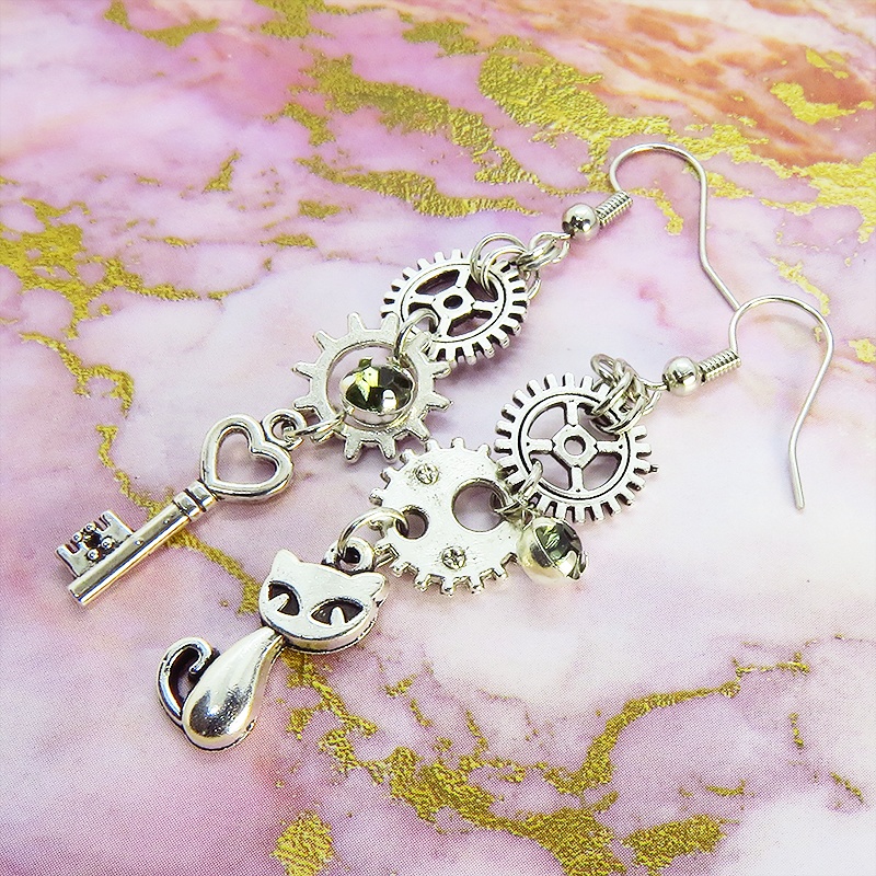 アンティークシルバー 猫と歯車・カギを組み合わせたスチームパンク風ピアス クリアガラス 深緑 サージカル可