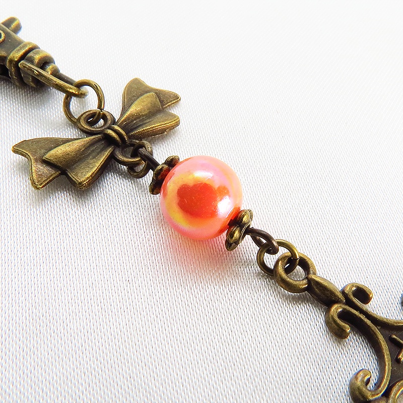 アンティークゴールド ロザリオとリボンの組み合わせにオレンジミックスビーズキーホルダー ファスナーチャーム