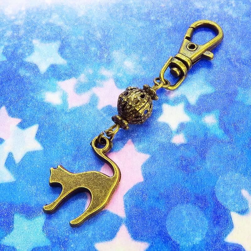 アンティークカラーの跳ね猫モチーフと透かしメタルビーズのファスナーチャーム キーホルダー