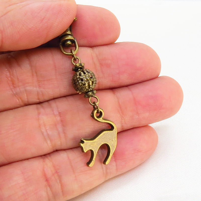 アンティークカラーの跳ね猫モチーフと透かしメタルビーズのファスナーチャーム キーホルダー