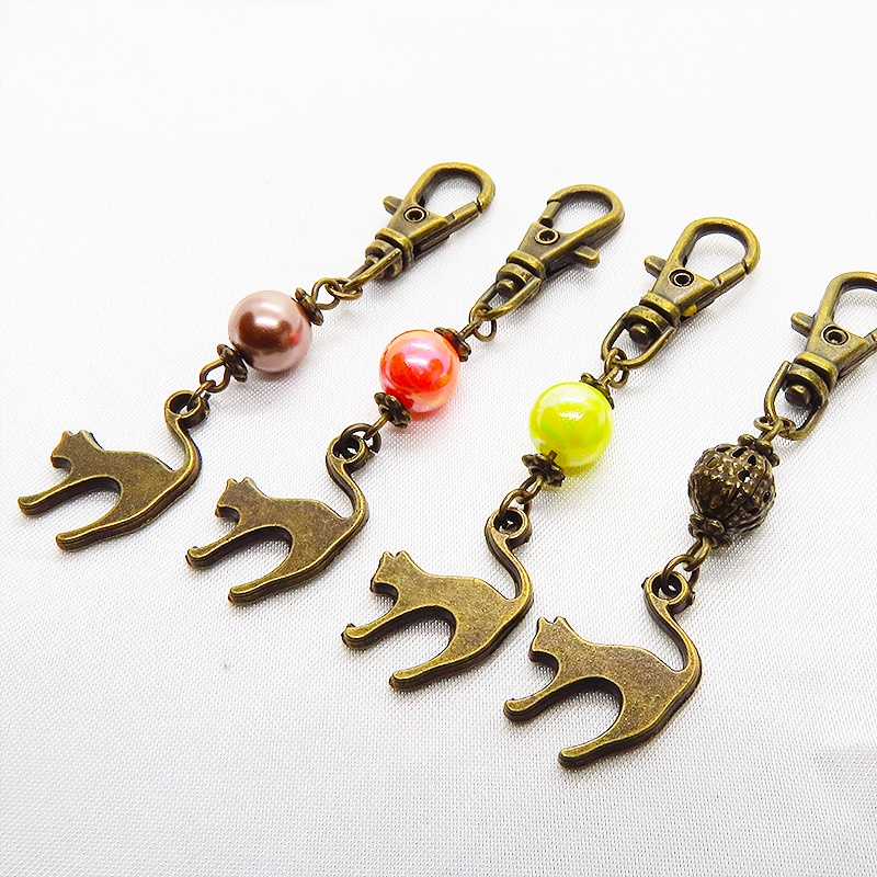 アンティークカラーの跳ね猫モチーフと透かしメタルビーズのファスナーチャーム キーホルダー