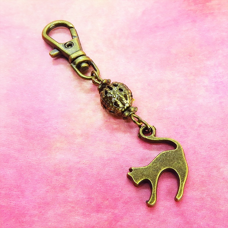 アンティークカラーの跳ね猫モチーフと透かしメタルビーズのファスナーチャーム キーホルダー