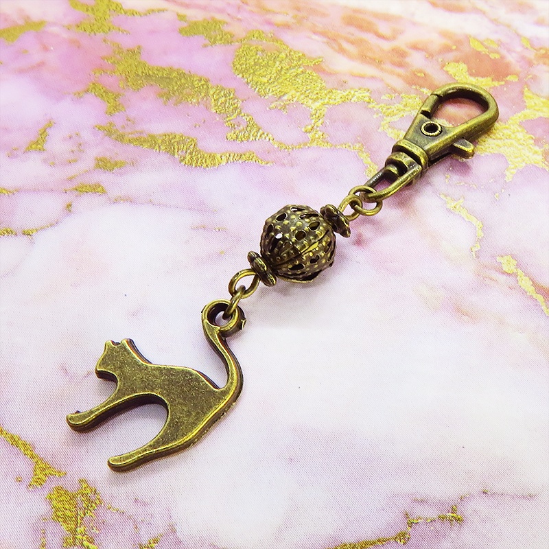 アンティークカラーの跳ね猫モチーフと透かしメタルビーズのファスナーチャーム キーホルダー