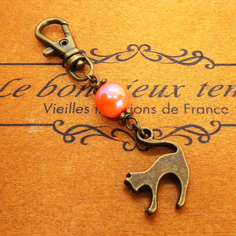 アンティークカラーの跳ね猫モチーフとオレンジミックスビーズのファスナーチャーム キーホルダー