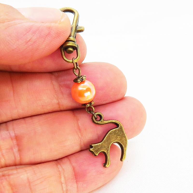 アンティークカラーの跳ね猫モチーフとオレンジミックスビーズのファスナーチャーム キーホルダー