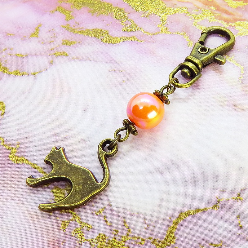アンティークカラーの跳ね猫モチーフとオレンジミックスビーズのファスナーチャーム キーホルダー