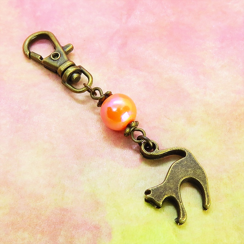 アンティークカラーの跳ね猫モチーフとオレンジミックスビーズのファスナーチャーム キーホルダー
