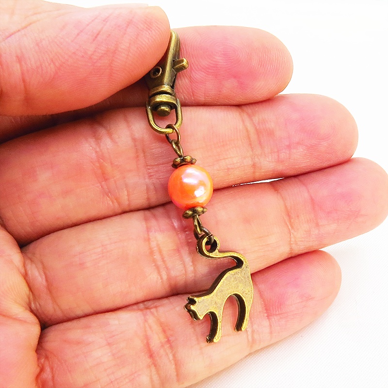 アンティークカラーの跳ね猫モチーフとオレンジミックスビーズのファスナーチャーム キーホルダー
