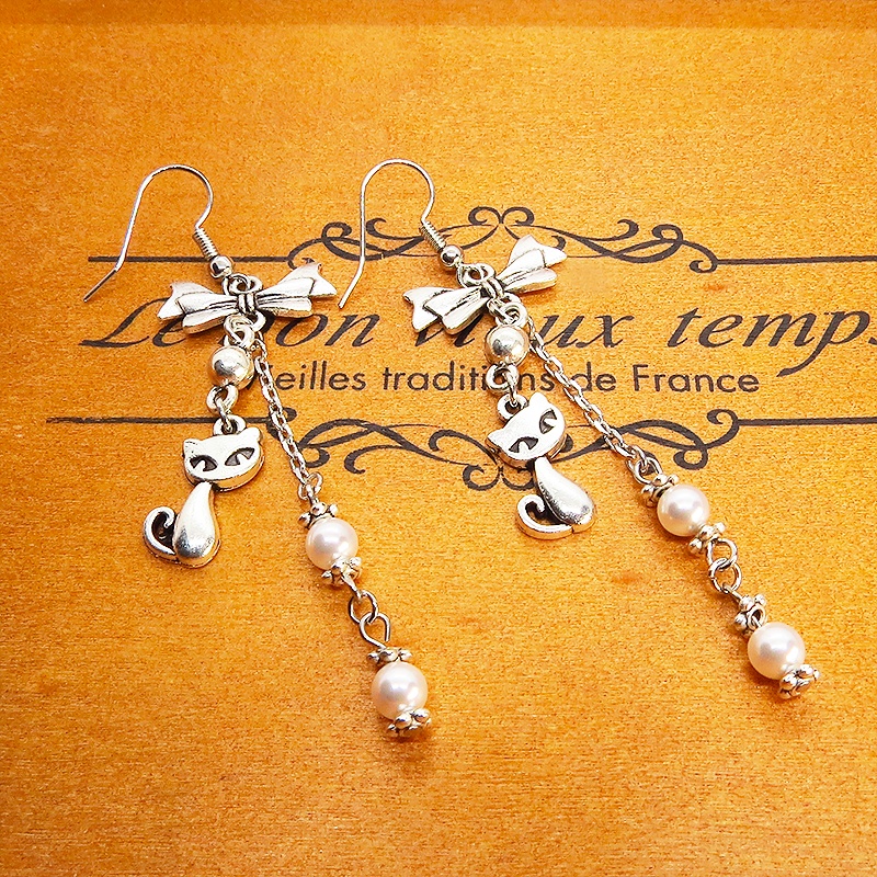 アンティークシルバーの猫モチーフとリボンのロングチェーンピアス スワロフスキーパール