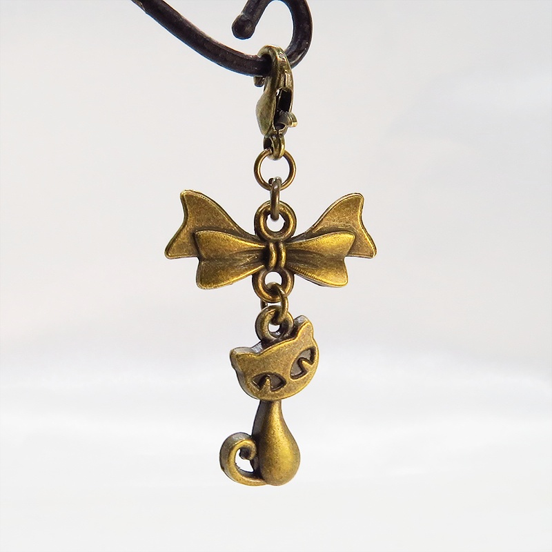 マスク・スマホチャーム アンティークゴールド 猫モチーフとリボンのコンパクトで可愛いチャーム ジャックピン追加可