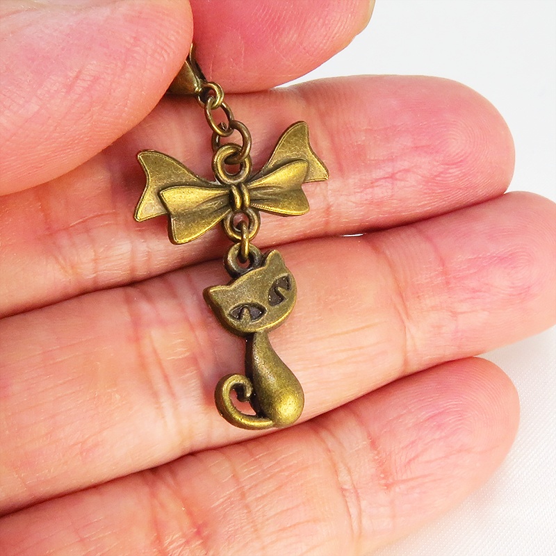 マスク・スマホチャーム アンティークゴールド 猫モチーフとリボンのコンパクトで可愛いチャーム ジャックピン追加可