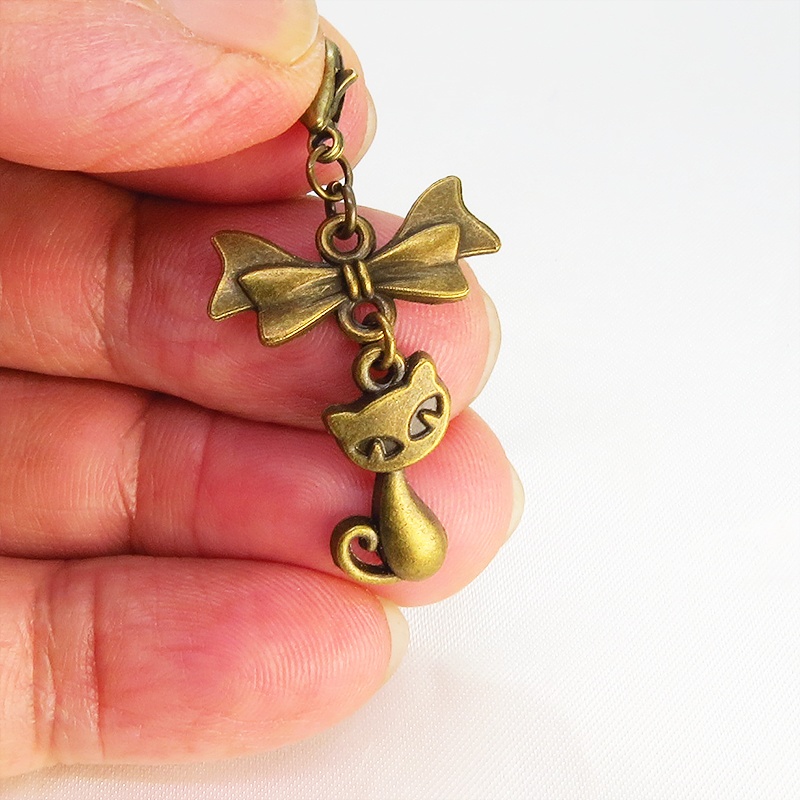 マスク・スマホチャーム アンティークゴールド 猫モチーフとリボンのコンパクトで可愛いチャーム ジャックピン追加可