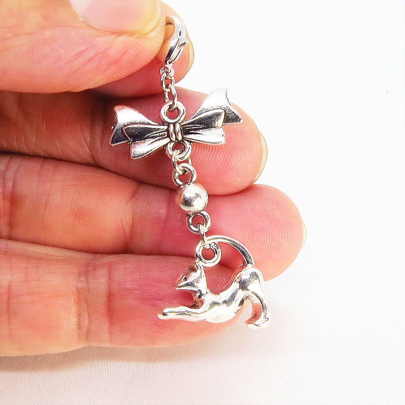 のび猫をかたどったシルエットモチーフとリボンの可愛いマスクチャーム アンティークシルバー