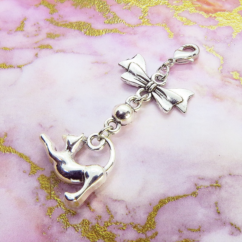 のび猫をかたどったシルエットモチーフとリボンの可愛いマスクチャーム アンティークシルバー