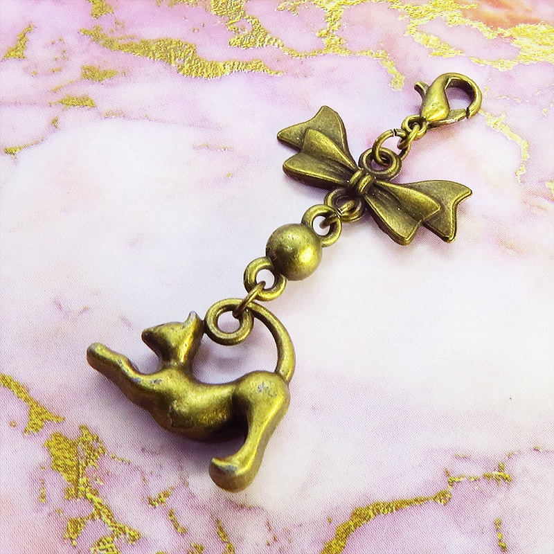 のび猫をかたどったシルエットモチーフとリボンの可愛いマスクチャーム アンティークカラー