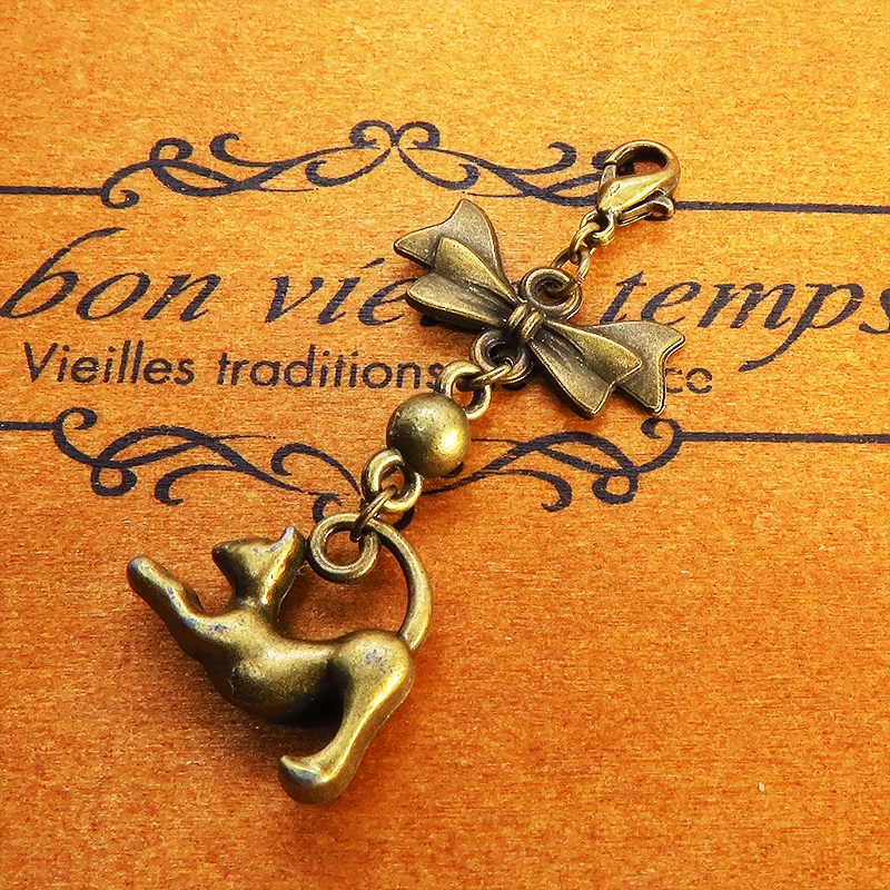 のび猫をかたどったシルエットモチーフとリボンの可愛いマスクチャーム アンティークカラー