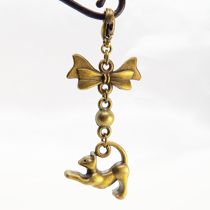 のび猫をかたどったシルエットモチーフとリボンの可愛いマスクチャーム アンティークカラー