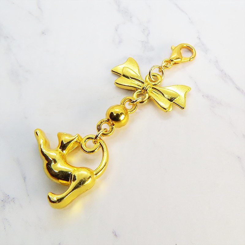 のび猫をかたどったシルエットモチーフとリボンの可愛いマスクチャーム ゴールドカラー