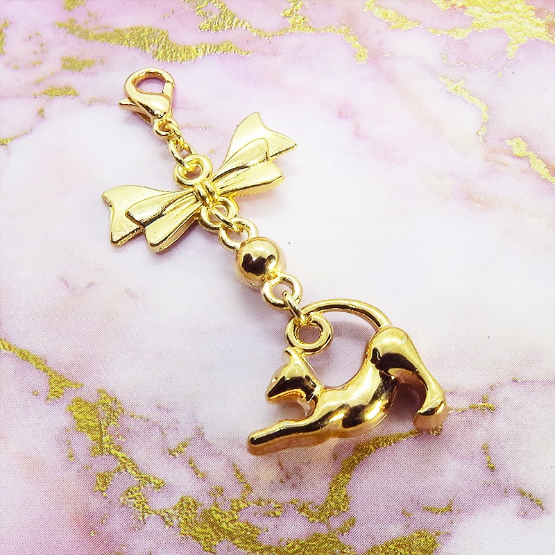 のび猫をかたどったシルエットモチーフとリボンの可愛いマスクチャーム マットゴールド