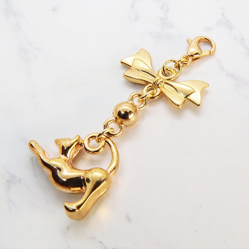 のび猫をかたどったシルエットモチーフとリボンの可愛いマスクチャーム マットゴールド