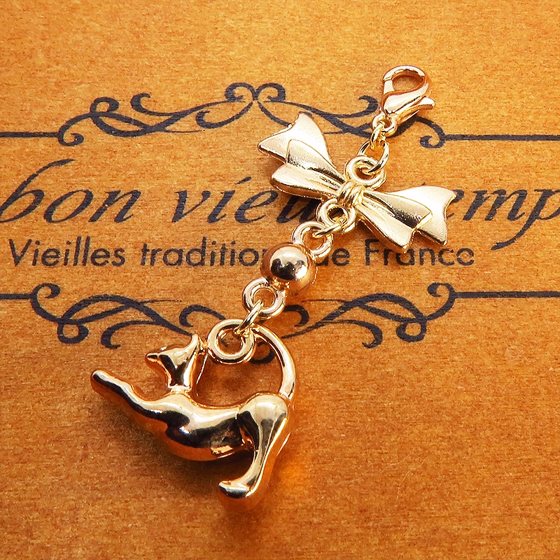 のび猫をかたどったシルエットモチーフとリボンの可愛いマスクチャーム マットゴールド