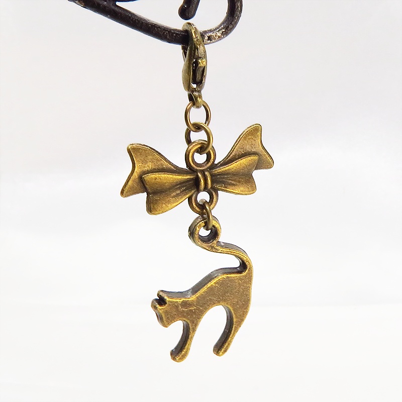 マスクチャーム アンティークカラー(金古美色)の跳ね猫とリボンの大人可愛いチャーム キーホルダー