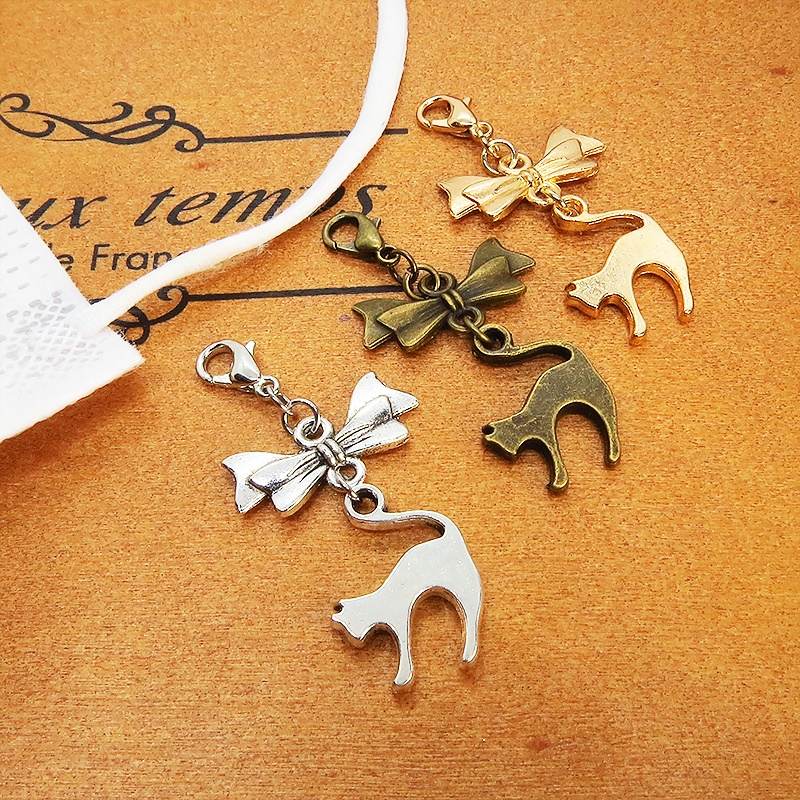 マスクチャーム アンティークカラー(金古美色)の跳ね猫とリボンの大人可愛いチャーム キーホルダー