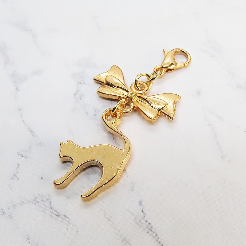 マスクチャーム マットゴールドの跳ね猫とリボンの大人可愛いチャーム キーホルダー