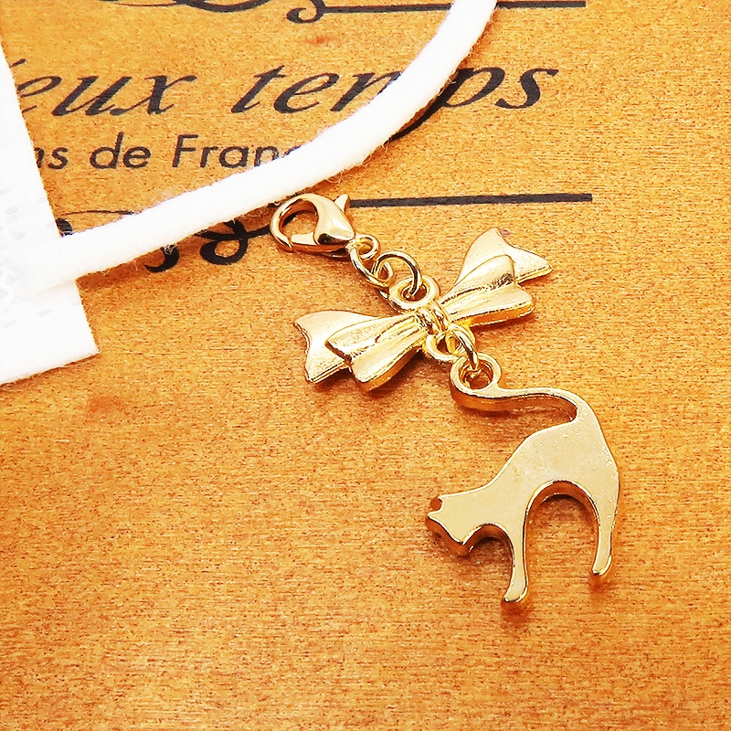 マスクチャーム マットゴールドの跳ね猫とリボンの大人可愛いチャーム キーホルダー
