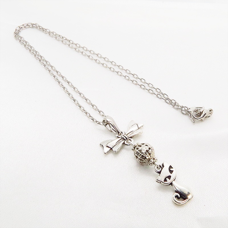 アンティークシルバーの猫とリボンと透かしメタルビーズのチャームのネックレス