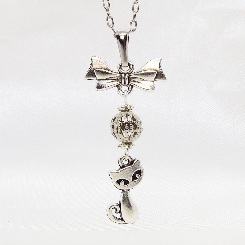 アンティークシルバーの猫とリボンと透かしメタルビーズのチャームのネックレス