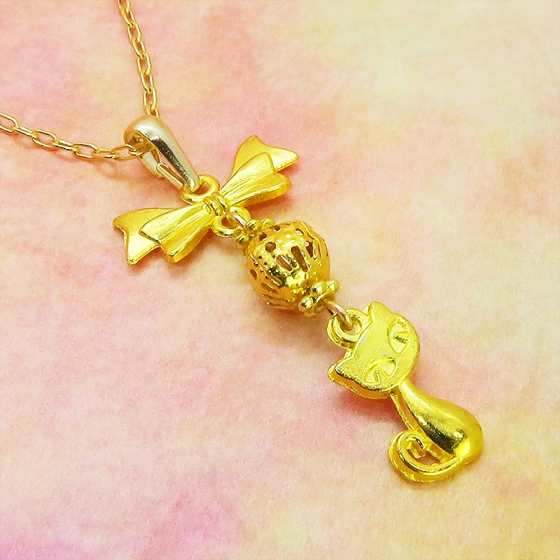 ゴールドカラーの猫とリボンと透かしメタルビーズのチャームのネックレス