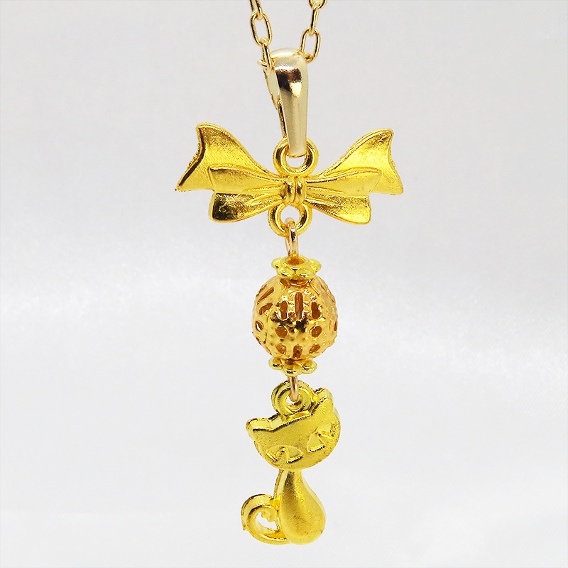 ゴールドカラーの猫とリボンと透かしメタルビーズのチャームのネックレス