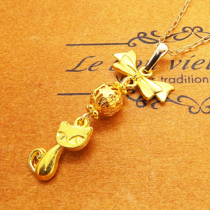 ゴールドカラーの猫とリボンと透かしメタルビーズのチャームのネックレス