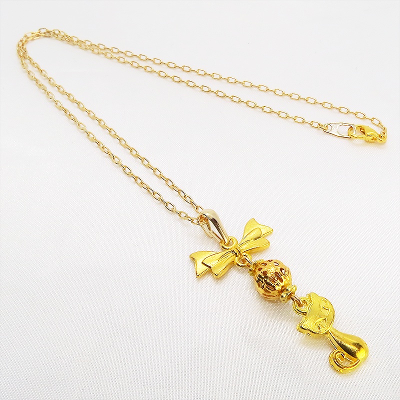 ゴールドカラーの猫とリボンと透かしメタルビーズのチャームのネックレス