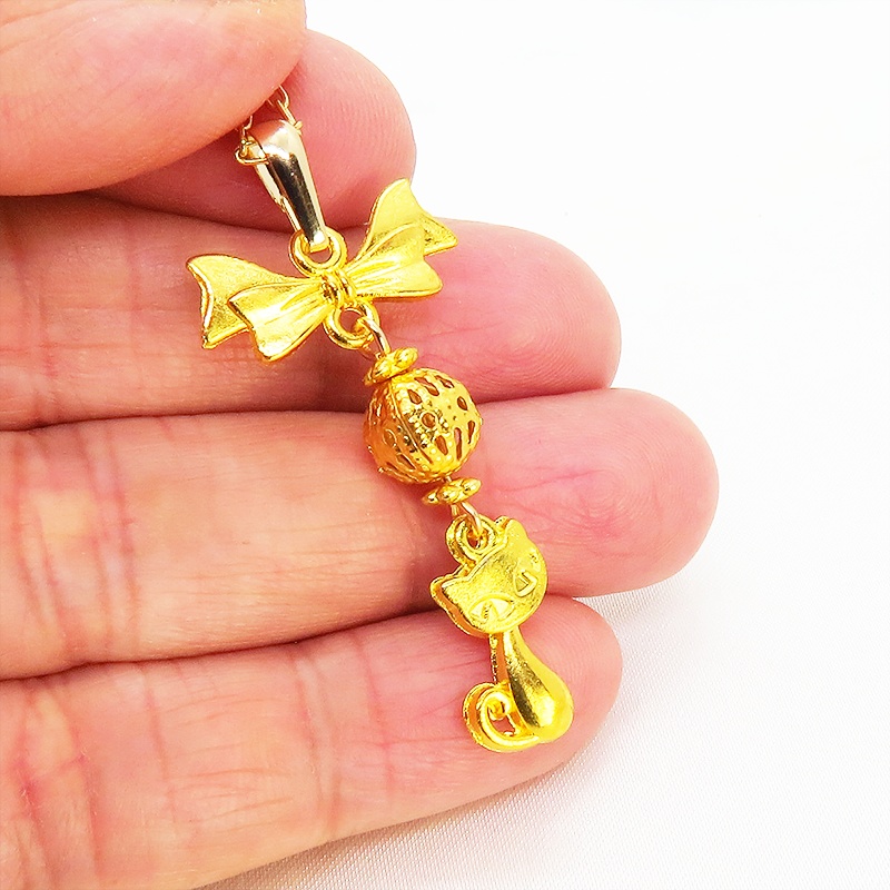 ゴールドカラーの猫とリボンと透かしメタルビーズのチャームのネックレス