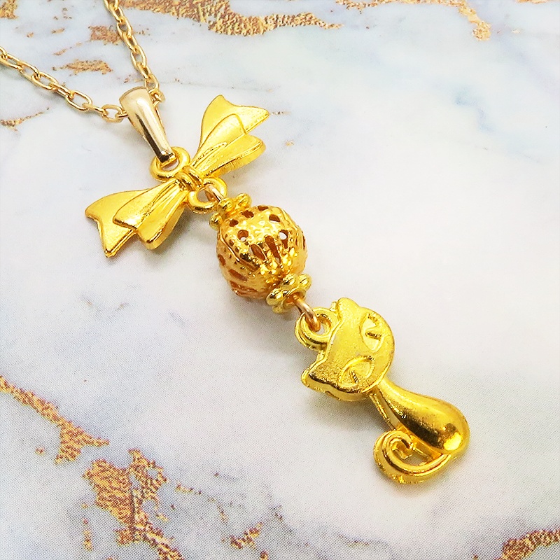 ゴールドカラーの猫とリボンと透かしメタルビーズのチャームのネックレス