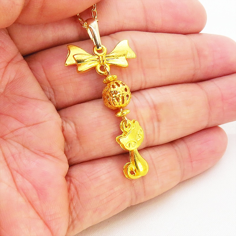 ゴールドカラーの猫とリボンと透かしメタルビーズのチャームのネックレス