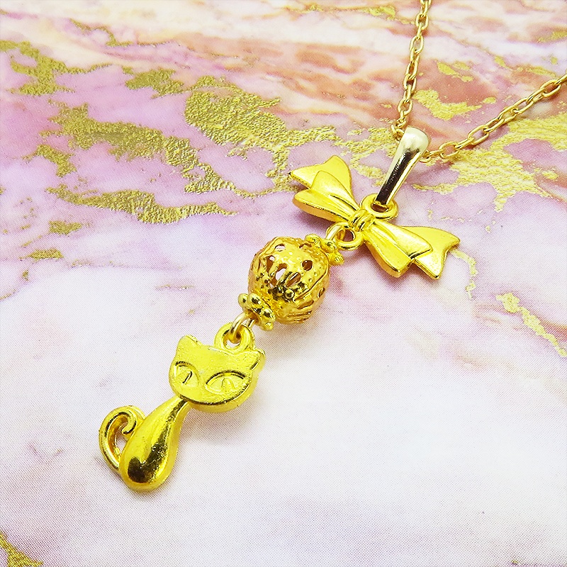 ゴールドカラーの猫とリボンと透かしメタルビーズのチャームのネックレス