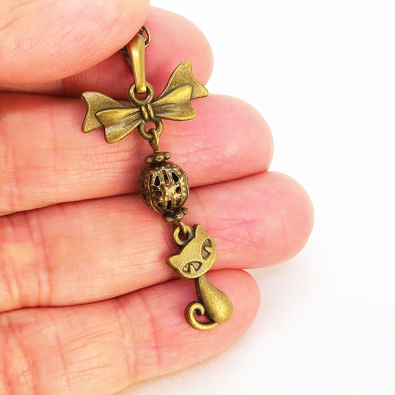 アンティークカラーの猫とリボンと透かしメタルビーズのチャームのネックレス