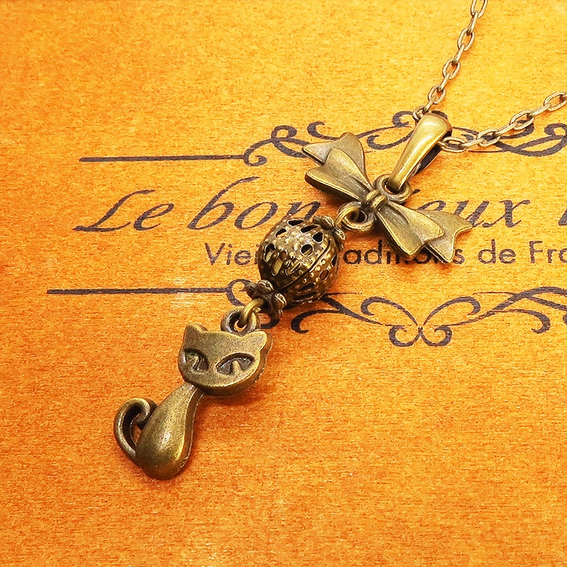 アンティークカラーの猫とリボンと透かしメタルビーズのチャームのネックレス