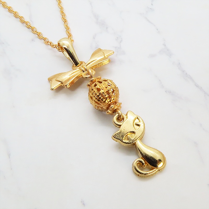 マットゴールドの猫とリボンと透かしメタルビーズのチャームのネックレス