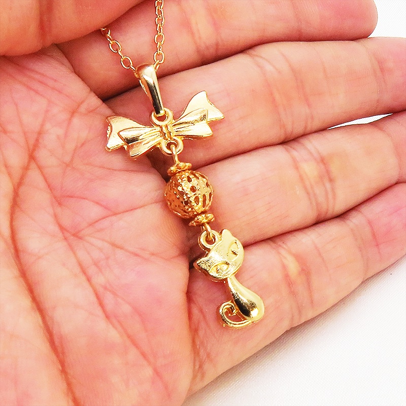 マットゴールドの猫とリボンと透かしメタルビーズのチャームのネックレス