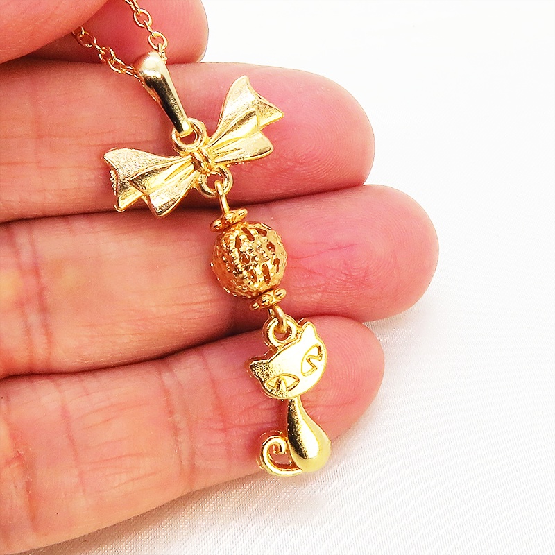 マットゴールドの猫とリボンと透かしメタルビーズのチャームのネックレス