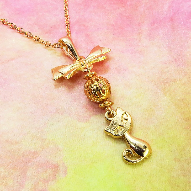 マットゴールドの猫とリボンと透かしメタルビーズのチャームのネックレス