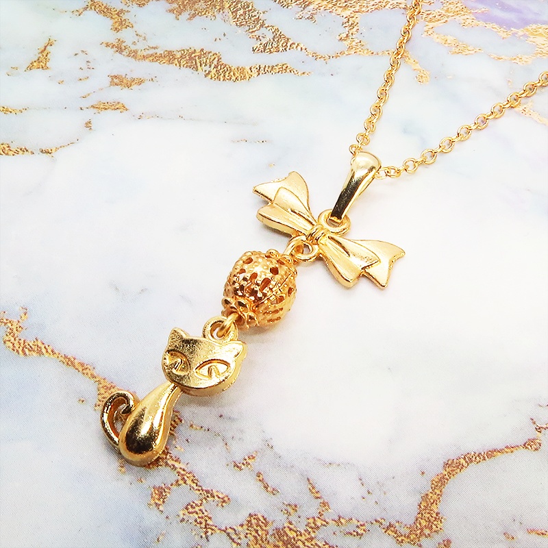 マットゴールドの猫とリボンと透かしメタルビーズのチャームのネックレス