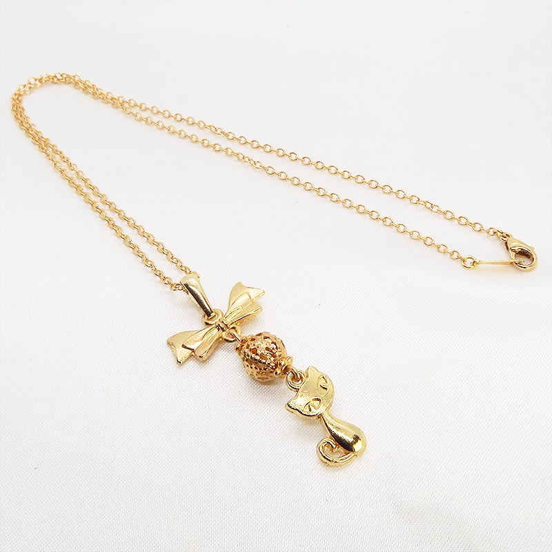 マットゴールドの猫とリボンと透かしメタルビーズのチャームのネックレス