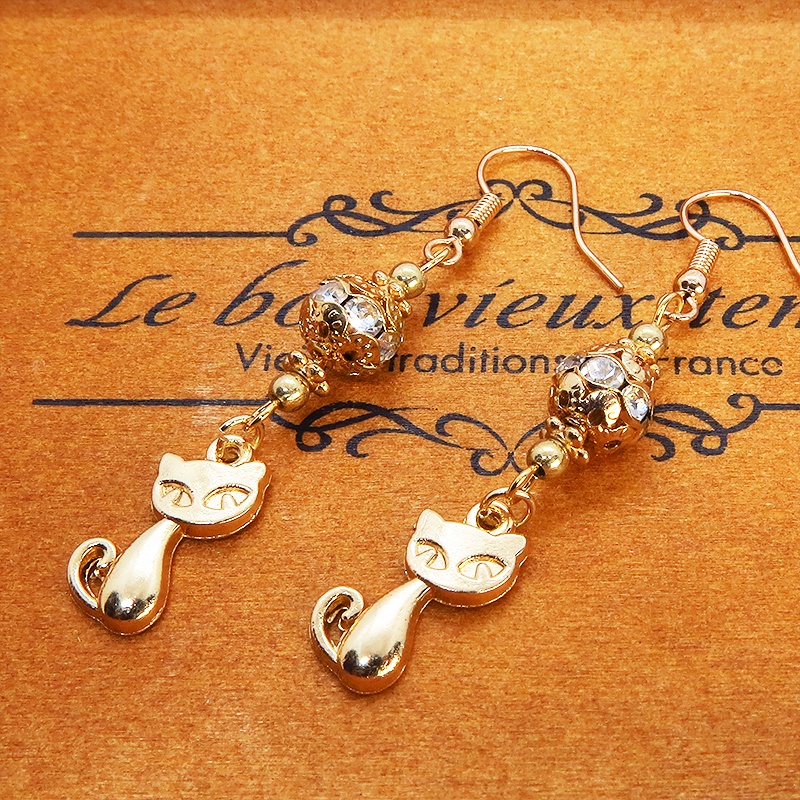 マットゴールドの猫のチャームとキラキラ光るガラス入りのメタルビースのピアス
