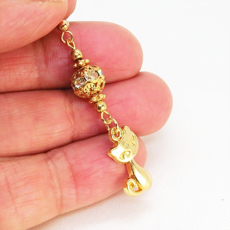 マットゴールドの猫のチャームとキラキラ光るガラス入りのメタルビースのピアス